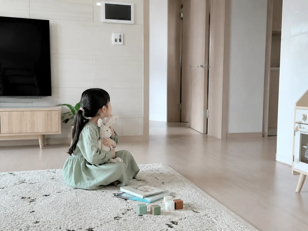거실 바닥에 혼자 앉아 있는 아이