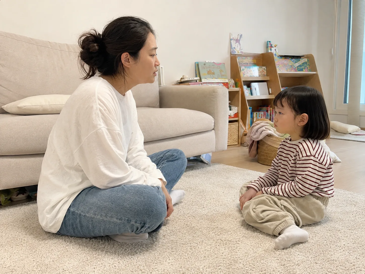 아이와 마주 앉아 이야기를 나누는 엄마