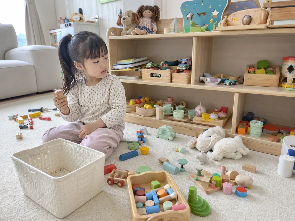 장난감이 바닥에 잔뜩 펼쳐진 방에서 노는 아이