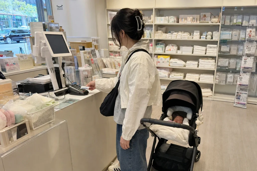 유모차를 끌고 매장에서 육아용품을 계산하는 엄마