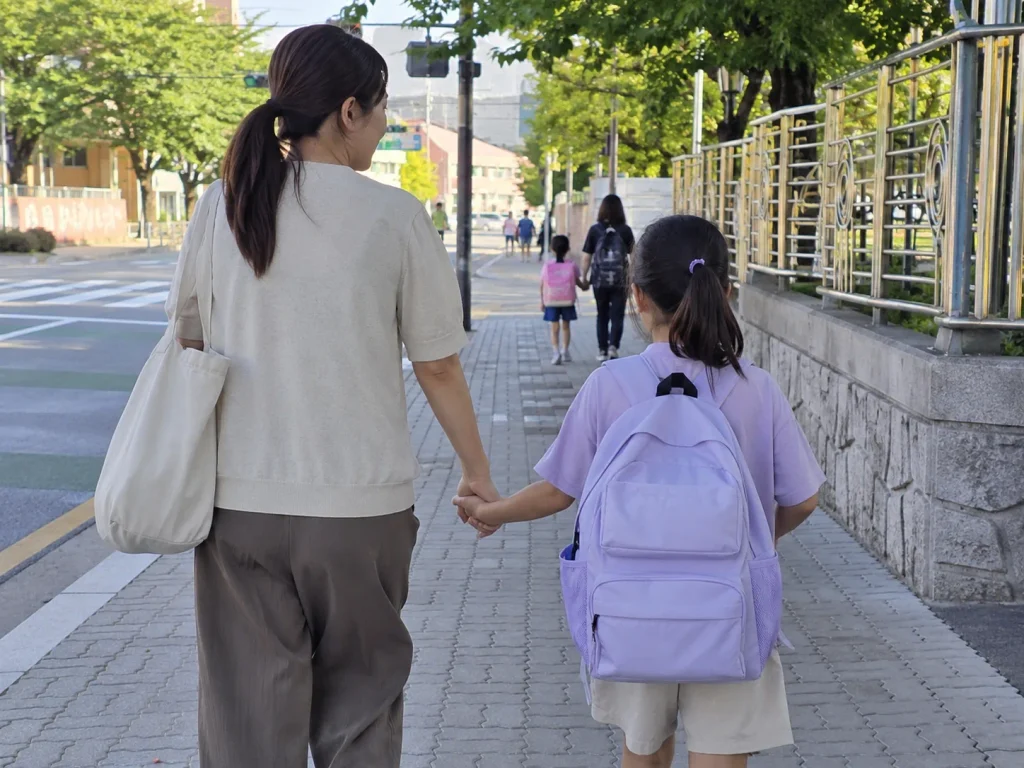 엄마 손을 잡고 등교하는 초등학생 아이