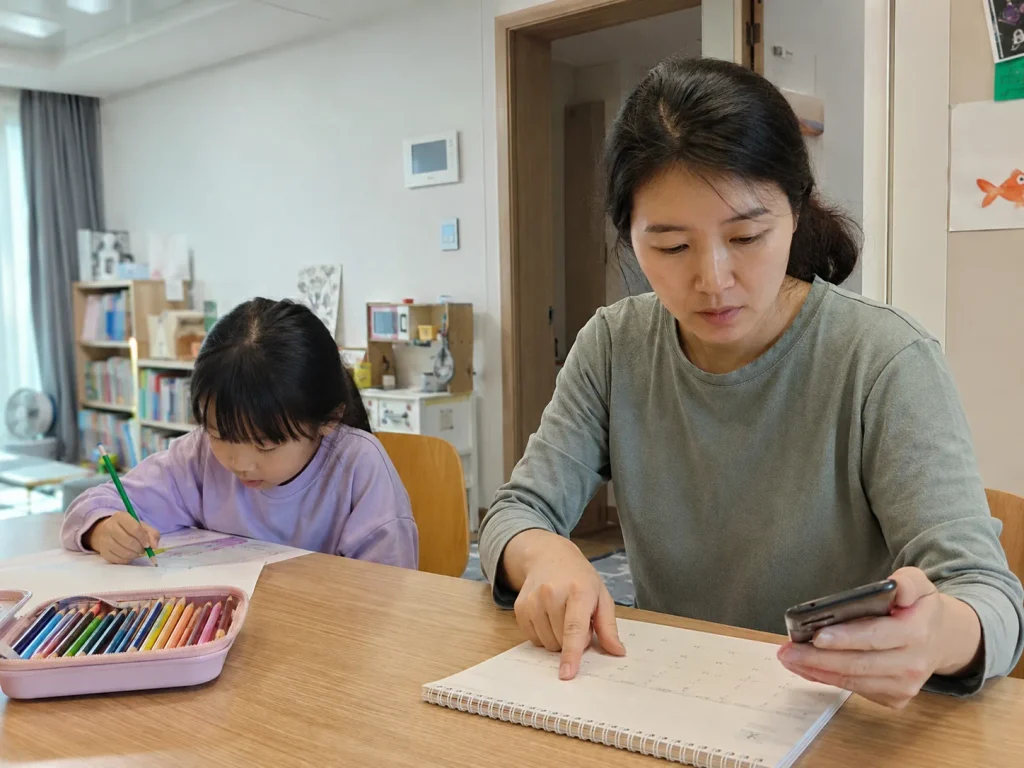 아이 옆에서 서류를 확인하는 엄마