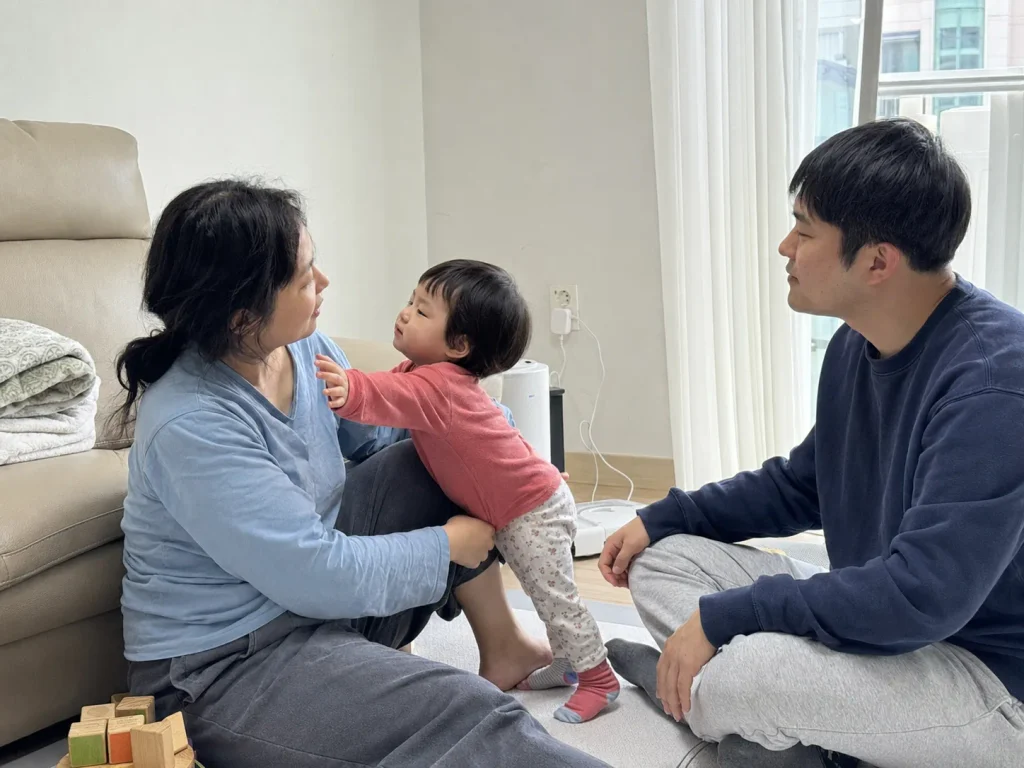 거실에서 엄마 아빠 사이에서 노는 아이