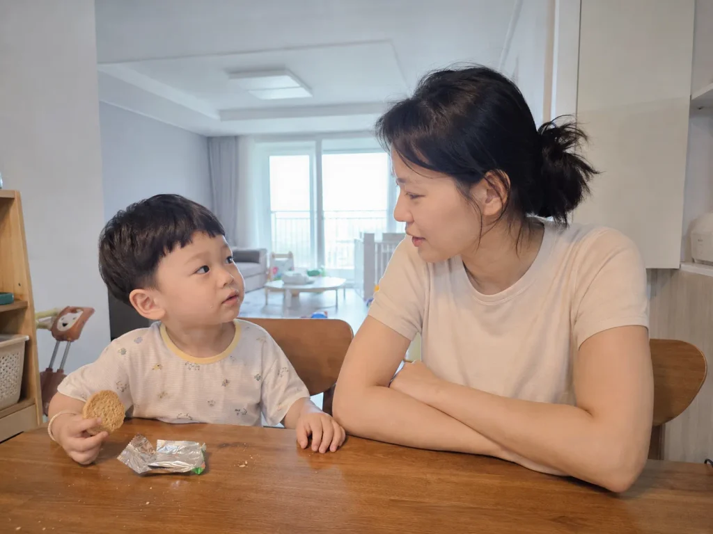 식탁에 마주 앉아 아이와 차분하게 이야기하는 엄마