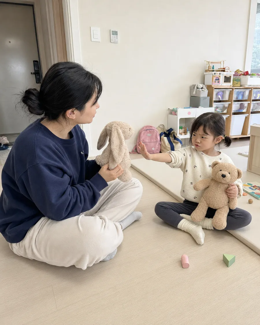 인형으로 역할놀이하며 싫어 하지 마를 연습하는 아이