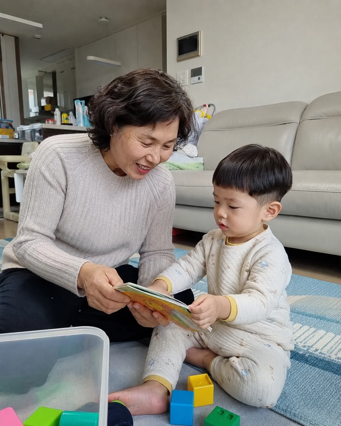 할머니와 함께 그림책을 보는 손주
