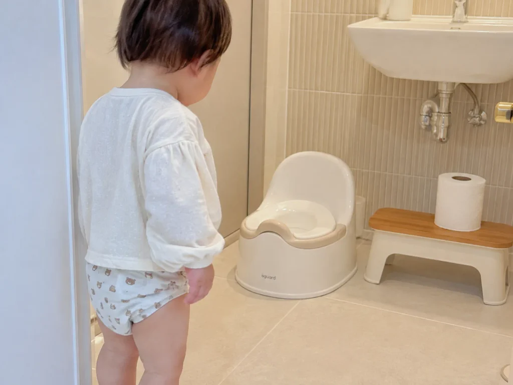 화장실에서 아기 변기 앞에 서 있는 아이