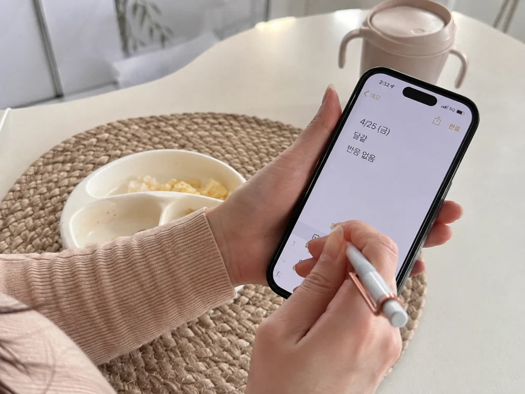 휴대폰 메모장에 이유식 알레르기 반응을 기록하는 엄마